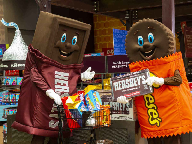 Hershey bar and Reese's mascots shopping in Hershey's Chocolate World